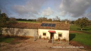 Complejo Rural Dehesa de Ituero的顶部有太阳能电池组的房子