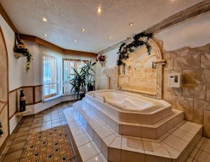 贝旺阿尔姆劳什贝格酒店的大型浴室设有大浴缸。
