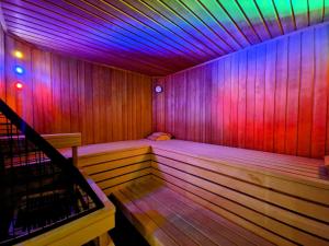贝旺阿尔姆劳什贝格酒店的一间拥有紫色和粉色灯光的木制桑拿浴室