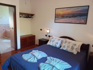 乌巴图巴Solar das Canoas Prumirim的一间带蓝色床的卧室和一间浴室