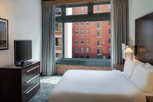 波士顿波士顿市中心万豪海港酒店的酒店客房设有一张床和一个大窗户