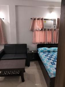 菩提伽耶Darbar Villa的小房间设有床和沙发