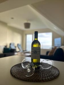 邓莫尔东Dunmore East Holiday and Golf Resort Apartments的桌子上放一瓶葡萄酒和玻璃杯