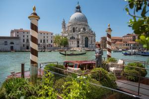 威尼斯The St. Regis Venice的站在水面上靠近建筑物的人