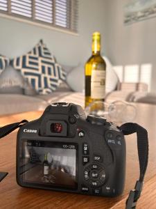 邓莫尔东Dunmore East Ocean View Suite的一张桌子上的摄像头,上面放着一瓶葡萄酒