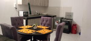 蒙巴萨Precious Moments Suite的带桌椅的厨房和带水槽的厨房