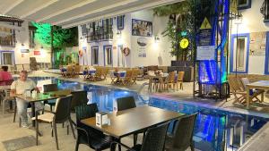 博德鲁姆伊斯坦科酒店的餐厅的中间设有一座游泳池,配有桌椅