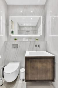 伦敦Luxury 3 bedroom apartment in the heart of High Street Kensington, London.的白色的浴室设有卫生间和水槽。