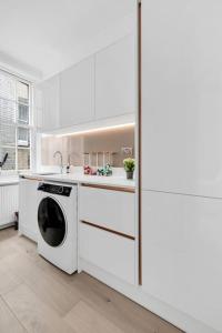 伦敦Luxury 3 bedroom apartment in the heart of High Street Kensington, London.的白色的厨房配有洗碗机和水槽