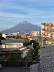 富士市MR TOMO FUJI的一座城市背景中的山,有建筑