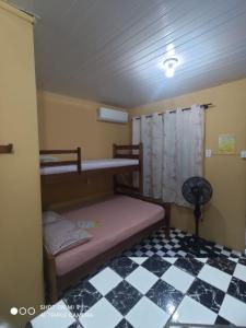 蜜岛Morada das Flores Chalé/Kitnet的一间卧室设有两张双层床和一张可调节的地板。