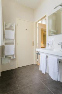 阿宰勒里多帝王大酒店的浴室配有盥洗盆、镜子和毛巾