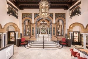 塞维利亚Hotel Alfonso XIII, a Luxury Collection Hotel, Seville的大堂设有大吊灯和楼梯