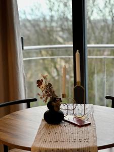 沃特福德City Pulse Apartment的一张桌子,上面有蜡烛和花瓶