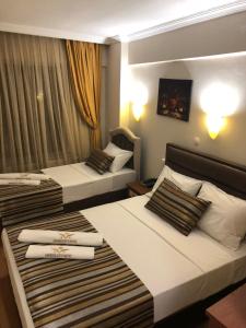 伊斯坦布尔MARDİA CİTY OTEL的两张位于酒店客房的床,配有毛巾