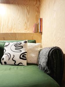斯普里蒙Bayda's Tiny House的绿沙发,上面有枕头,上面有枕头,还有枕头