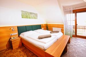 加姆利茨萨特勒霍夫韦恩古特酒店的一间卧室配有一张大床和绿色床头板