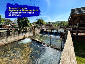 热河市Casa Para Temporada - Com Acesso ao Rio Thermal的公园里的一个水池,有木栅