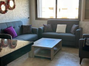 曼苏里亚Bel appartement à Malaga Beach El Mansouria的带沙发和咖啡桌的客厅