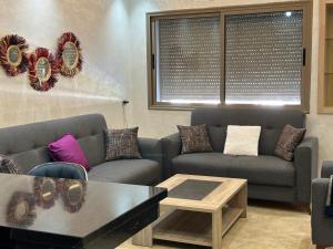 曼苏里亚Bel appartement à Malaga Beach El Mansouria的客厅配有两张沙发和一张咖啡桌