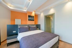 伊斯坦布尔Rise Inn Hotel的一间卧室配有一张带橙色墙壁的大床