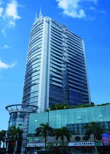 广州广州颐和商务酒店的一座高大的建筑,前面有棕榈树