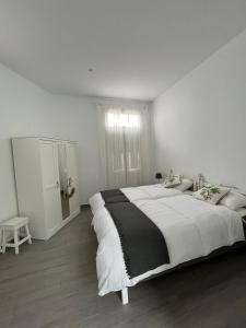 阿古洛Meriga的白色的卧室设有一张大床和一个窗户
