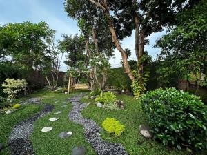 井里汶Roemah Uli Cirebon的一个带岩石路径和长凳的花园