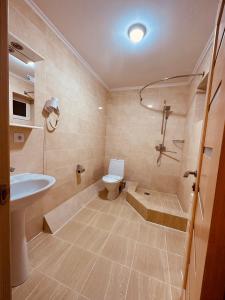 PogrebyРайский Дворик的带浴缸、卫生间和盥洗盆的浴室