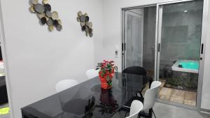 赫拉多拉Casa Mariposa的一间设有玻璃桌和白色椅子的用餐室