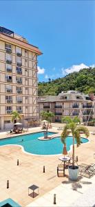 伊泰帕瓦Flat 217 Granja Brasil - Com Piscina Aquecida Em Itaipava的一座大型酒店,设有游泳池和一座建筑