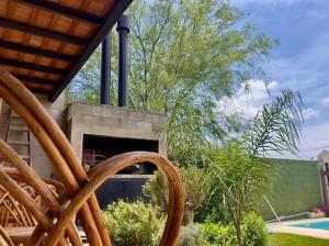 里奥夸尔托Casa Quinta FP en Rio Cuarto的一个带壁炉、一棵树和一个游泳池的庭院