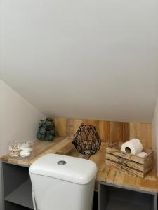 Petit Nid Douillet avec parking privé的浴室配有白色卫生间和木制柜台。
