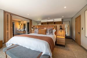 兰斯堡Bakubung Villas的一间卧室配有一张大床和木制床头板