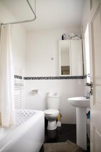 伦敦Luxury Cottage Room的白色的浴室设有卫生间和水槽。
