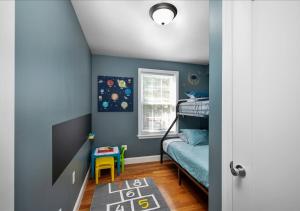 Mount VernonColorful, Comfy & Modern - Close to NYC - Parking!的一间拥有蓝色墙壁的卧室和一张双层床