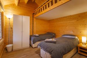 剑桥Spacious Log Cabin free Parking near Cambridge的木墙客房的两张床