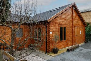 剑桥Spacious Log Cabin free Parking near Cambridge的一间设有窗户和屋顶的小木屋