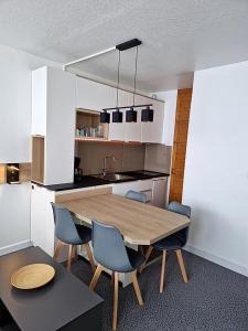 阿雷特Studio Moderne au pied des pistes 4 Pers - La Pierre Saint-Martin GR10的厨房配有木桌和椅子