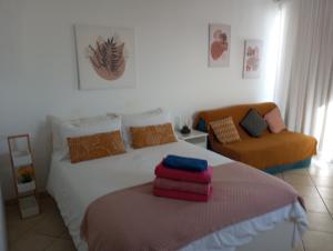 卡门港Apartamento Te Miti的一间卧室配有一张床和一张沙发