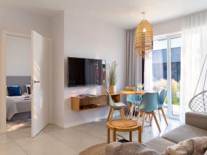 萨比诺瓦Comfortable apartments, swimming pool, Sarbinowo的客厅配有桌子和电视