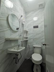 芭堤雅市中心The One Hotel的一间带卫生间、水槽和镜子的浴室
