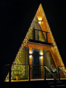 梅斯蒂亚B&B Cottage in Mestia的三角形的房子,上面有圣诞灯
