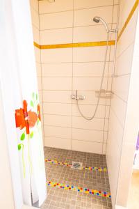 因特拉肯弗罗拉度假屋的带淋浴的浴室和瓷砖地板。