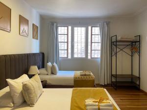 库斯科Katari at Plaza de Armas Cusco的酒店客房设有两张床和窗户。