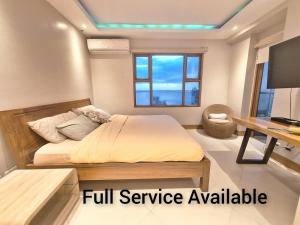 马尼拉Manila BayView Rental- Luxury 1,2,3,4 BR Condos with BALCONY POOL BAYVIEW - FULL SERVICE AVAILABLE的一间卧室配有一张床、一张书桌和一台电视