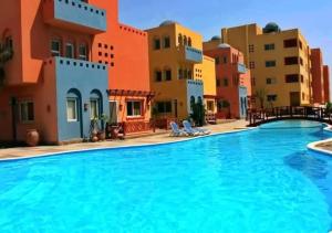赫尔格达Al Dora Residence Suites Hurghada的游泳池位于部分建筑前