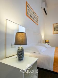 热那亚Acquario Suites的一间卧室配有一张床和一张桌子上的台灯
