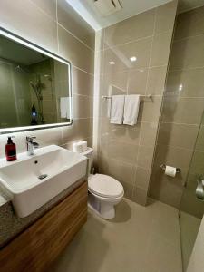 马尼拉Hotel Vibe Condo at Uptown Parksuites BGC的一间带水槽、卫生间和镜子的浴室