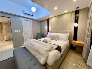 马尼拉Hotel Vibe Condo at Uptown Parksuites BGC的一间带大床的卧室和一间浴室